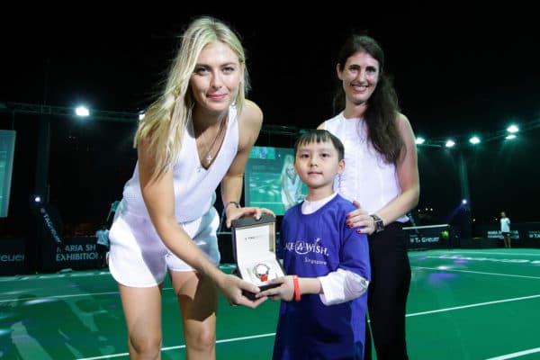 SINGAPORE - OCTOBER 22: Eight-year-old Joshua Ong (C), who suffers from non-Hodgkin lymphoma presents a TAG Heuer limited edition SG50 Aquaracer?to Maria Sharapova (L) as Amelia Sillard, VP, TAG Heuer South East Asia looks on during the Maria Sharapova Exhibition Match at Clifford Pier, Fullerton Bay Hotel on October 22, 2015 in Singapore. (Photo by Suhaimi Abdullah/Getty Images For TAG Heuer) *** Local Caption *** Maria Sharapova; Amelia Sillard; Joshua Ong