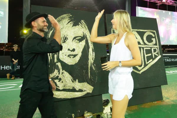 SINGAPORE - OCTOBER 22: Speed painting artist, Michael Raivard (L) high-five with Maria Sharapova after the speed painting contest infused with gold dust during the Maria Sharapova Exhibition Match at Clifford Pier, Fullerton Bay Hotel on October 22, 2015 in Singapore. (Photo by Suhaimi Abdullah/Getty Images For TAG Heuer) *** Local Caption *** Maria Sharapova; Michael Raivard
