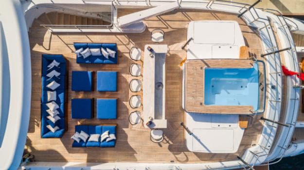 The stunning sundeck / bridge deck includes a comfortable lounge area, an aft-facing bar (also pictured bottom left) and a rectangular spa pool