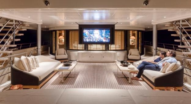 Bridge deck aft features an attractive al fresco lounge with large sofas, coffee tables and a retractable screen, ideal for a movie night to round off the day