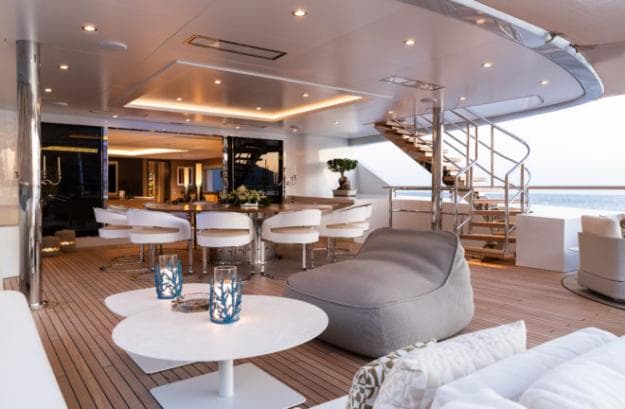 On the upper deck, or owner’s deck, the expansive covered aft area has a large, circular dining table for 10 and lots of seating space